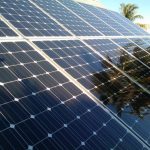 Up-close image of a residential solar installation being partially shaded by trees