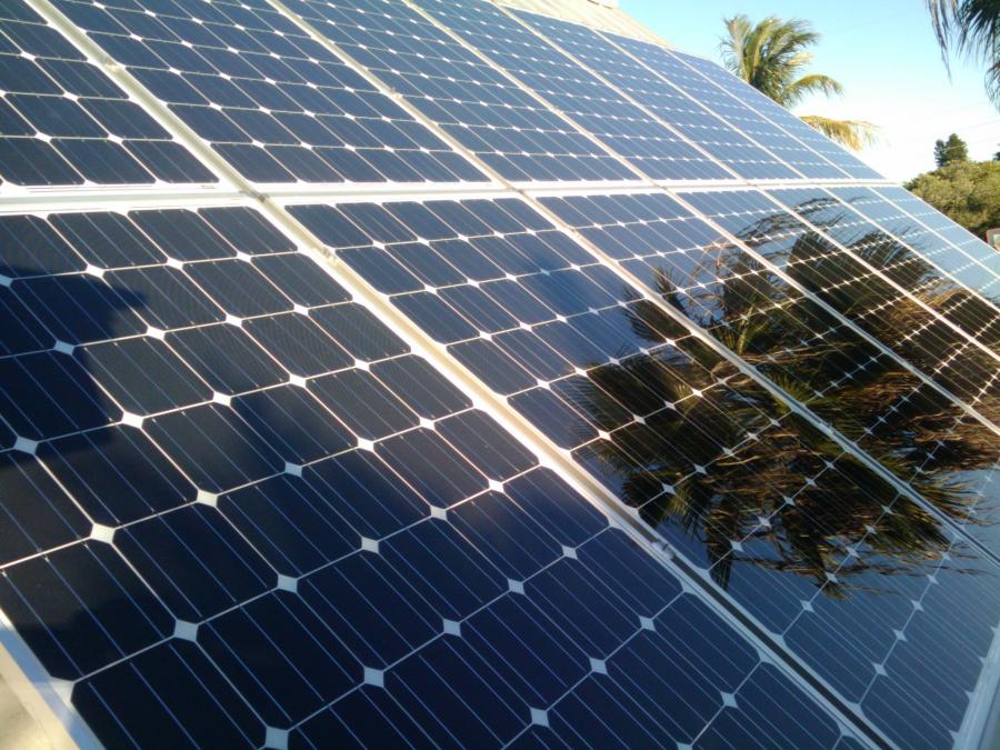 Up-close image of a residential solar installation being partially shaded by trees